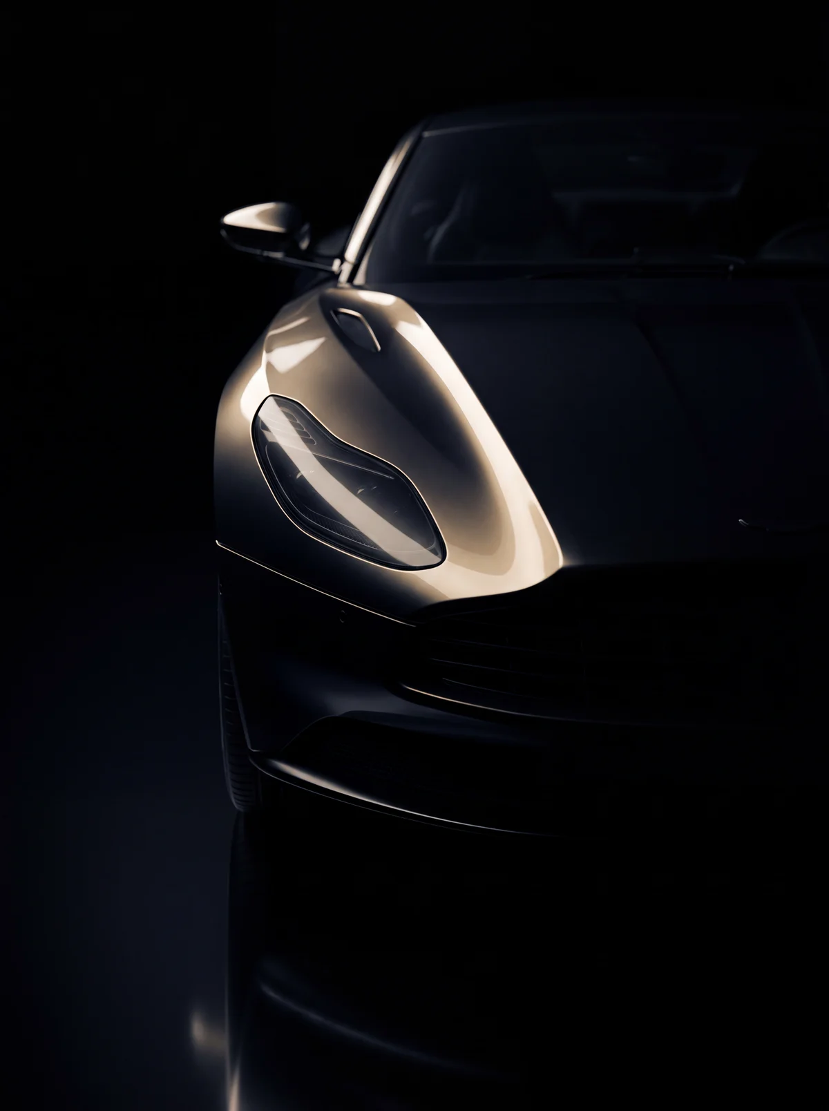 A single line of light tracing the curve of a black car's front fender in near darkness.